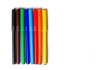 Obraz premium Markers of different colors lie in a row. On a white background.