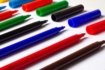 Markers of different colors at an angle. on a white background. caps separately.