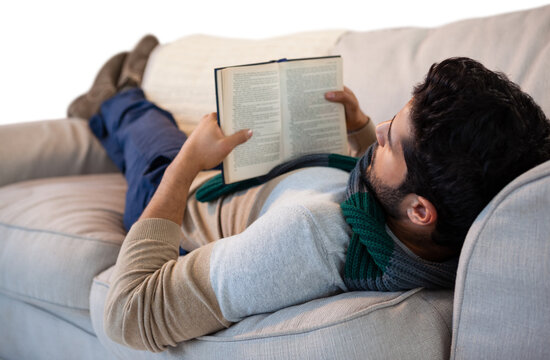 Full length of man lying on sofa while reading book