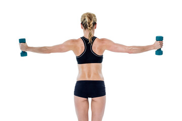 Fototapeta premium Female bodybuilder holding two dumbbells with arms out
