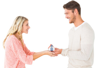 Attractive couple holding miniature house model
