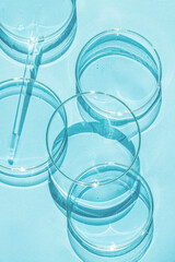 Petri dish. A set of Petri cups. A pipette, glass tube. On a blue blue background.
