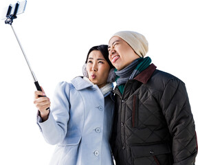 Playful couple taking selfie against building