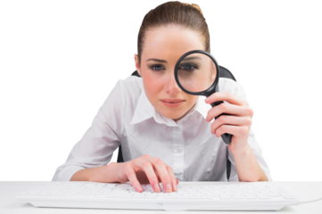 Businesswoman typing and looking through magnifying glass