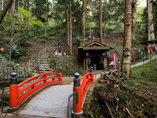 Red bridge and Buddhist pavilion on a mountain path leading to Iwayaji, temple number 45 of Shikoku...