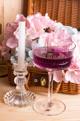 A glass glass-a creamer for drinks with colored drinks. Alcoholic fruit cocktail in a wicker basket...