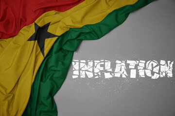 waving colorful national flag of ghana on a gray background with broken text inflation. 3d illustration