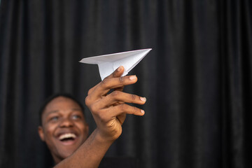 excited young black man holding a paper plane