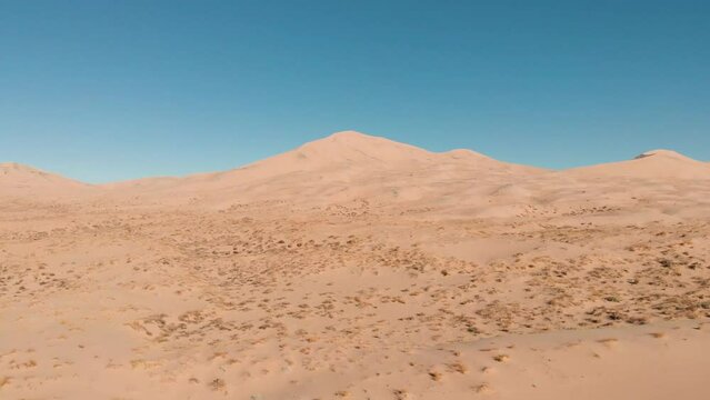 Aerial drone footage at Kelso Sand Dunes in the Mojave National Preserve Desert moving backward. Kelso, California.