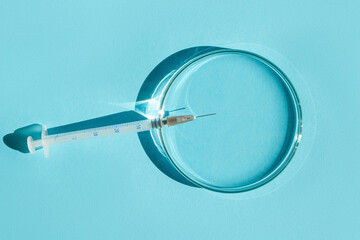 Petri dishes. small syringe. On a blue background.