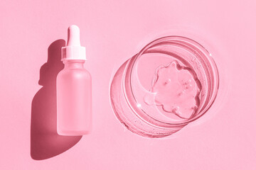Petri dish. With transparent gel. Cosmetics bottle. With a pipette. On a pink background.