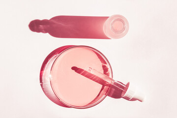 Petri dish. With pink liquid. With solution. Cosmetic pipette. Comedy bottle. On a white background.