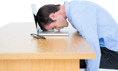Exhausted businessman resting head on laptop