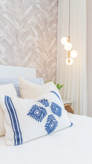 Dormitorio moderno con lampara colgante en el fondo con pared texturizada gris con diseño blanco.