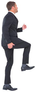 Businessman walking with his leg up 