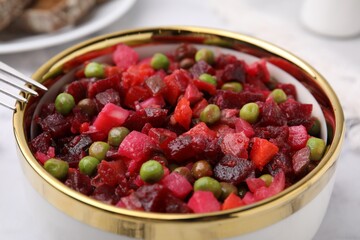 Delicious vinaigrette salad in bowl on table, closeup