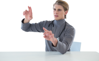 Male doctor touching imaginary interface screen while sitting at table