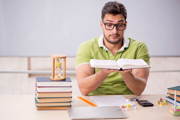 Young male student preparing for exams in the classroom