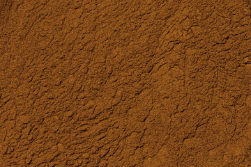 Old retro scratched yellow brown stucco on wall background, rust color orange stucco texture wall in old mexican building texture, cocoa powder, textured wall. earth, sand, clay, powder, roughness
