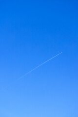 青い空を斜めに切るジェット旅客機の飛行機雲