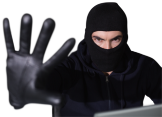 Hacker in balaclava gesturing and looking at camera