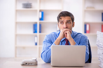 Young male employee and too much work in the office