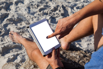 Man using digital tablet on the beach