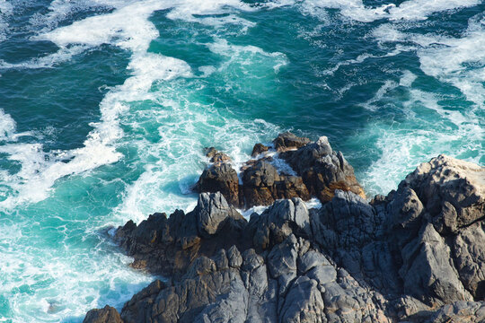 sea waves crash against the rocks