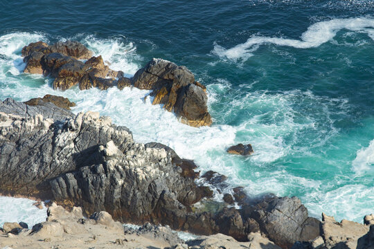 sea waves crash against the rocks