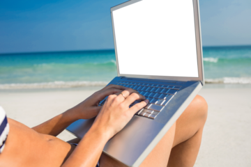 Woman using laptop on deck chair 