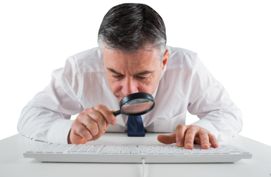 Mature businessman examining with magnifying glass