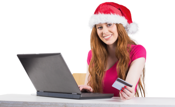 Festive redhead shopping online with laptop - Powered by Adobe