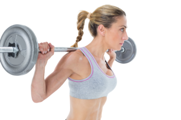 Strong female crossfitter lifting barbell behind head