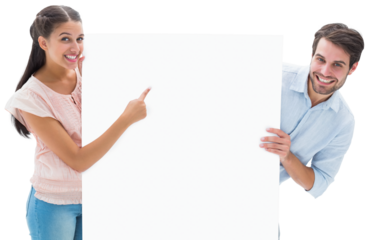 Attractive young couple smiling and holding poster