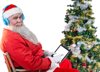 Santa Claus using digital tablet with christmas tree