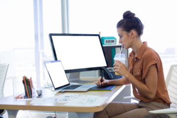 Female executive working over graphic tablet at her desk