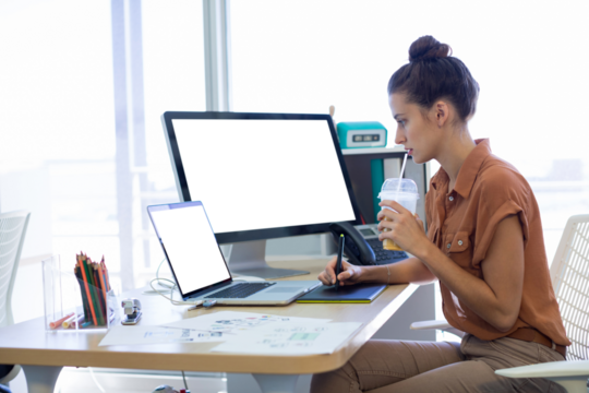 Female executive working over graphic tablet at her desk