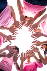 Directly below shot of females in pink outfits showing hands for breast cancer awareness