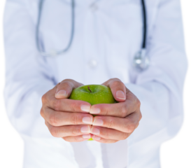 Midsection of female doctor holding green apple