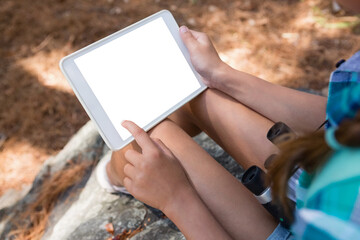 Close-up of girl holding digital tablet in the forest