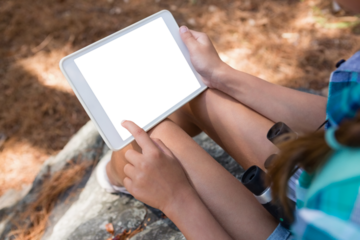 Close-up of girl holding digital tablet in the forest