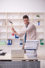 Young male employee unhappy with excessive work in the office