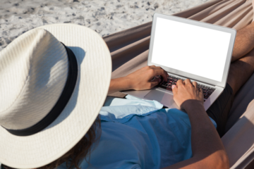 Man using laptop while relaxing on hammock