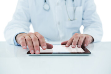 Doctor using digital tablet against white background