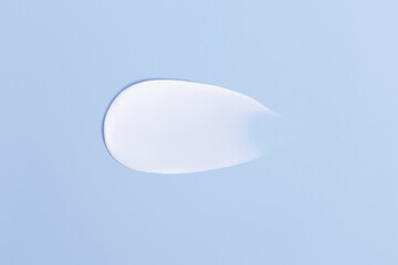 Close-up smear of cream texture on a blue background