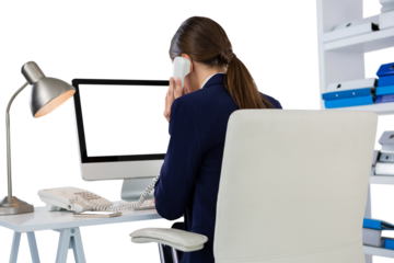 Businesswoman talking on phone at desk in office