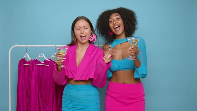 Happy Young women dressed in pink and blue clothes having fun in the boutique, as VIP clients drinking martini, shopping time concept, copy space, high quality video