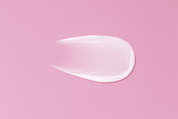 Close-up smear of cream texture on a pink background