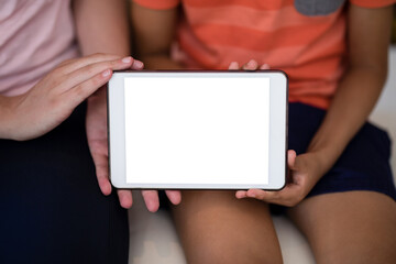Midsection of female therapist and boy showing digital tablet while sitting on bed