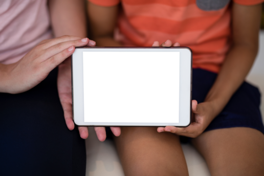 Midsection of female therapist and boy showing digital tablet while sitting on bed - Powered by Adobe